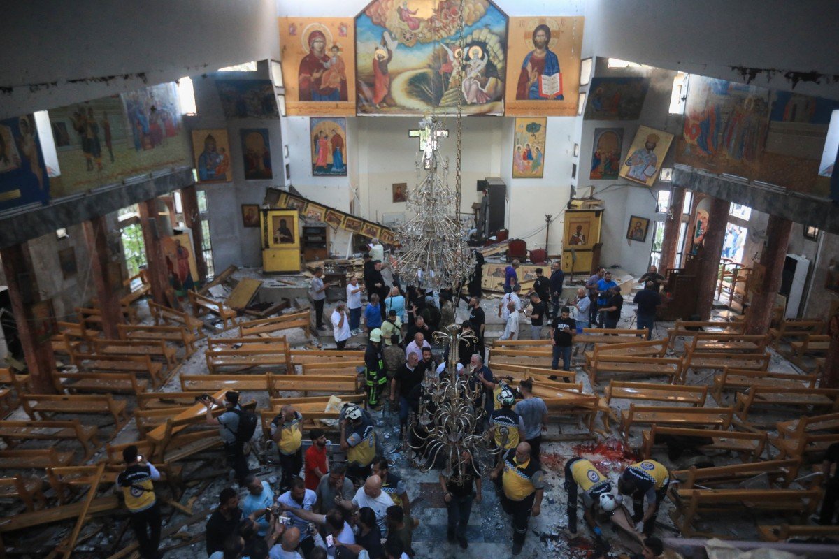 People-and-rescuers-inspect-the-damage-at-the-site-of-a-reported-suicide-attack-at-the-Saint-Elias-church-in-Damascus